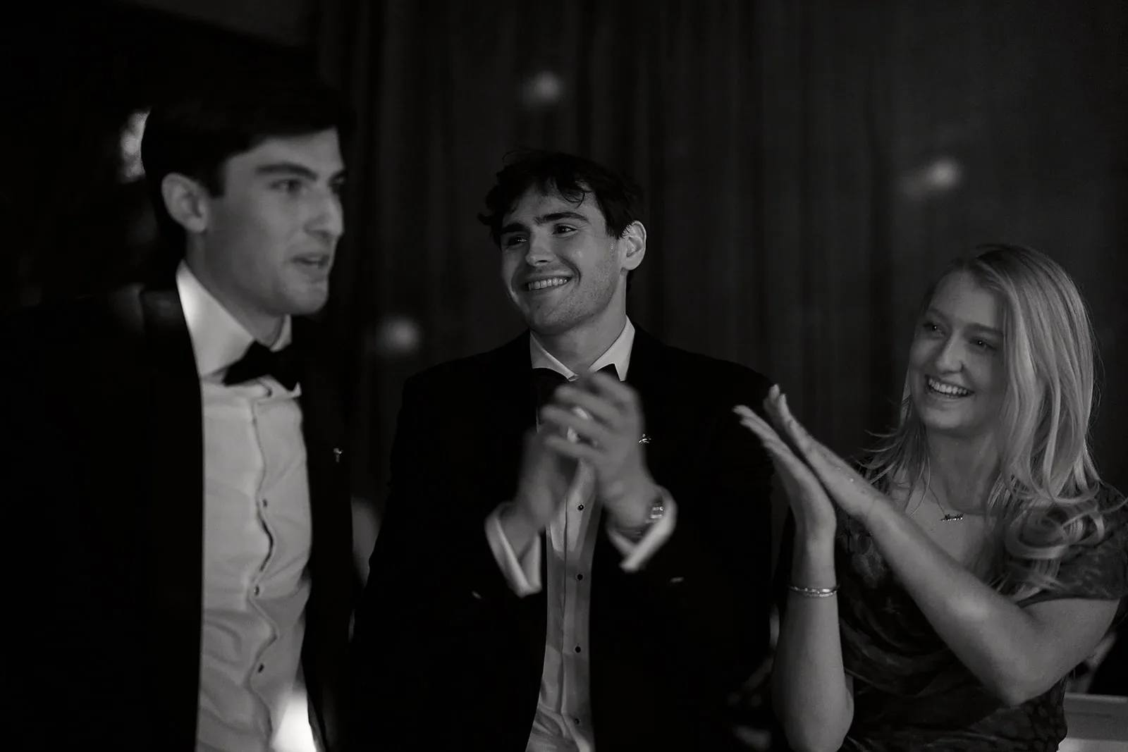 Guests applaud during the auction, in black and white.