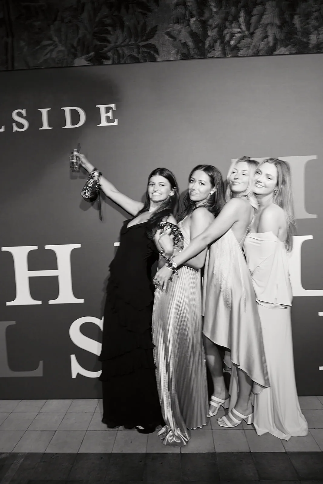 Four guests in gowns at the Hillside wall, in black and white.