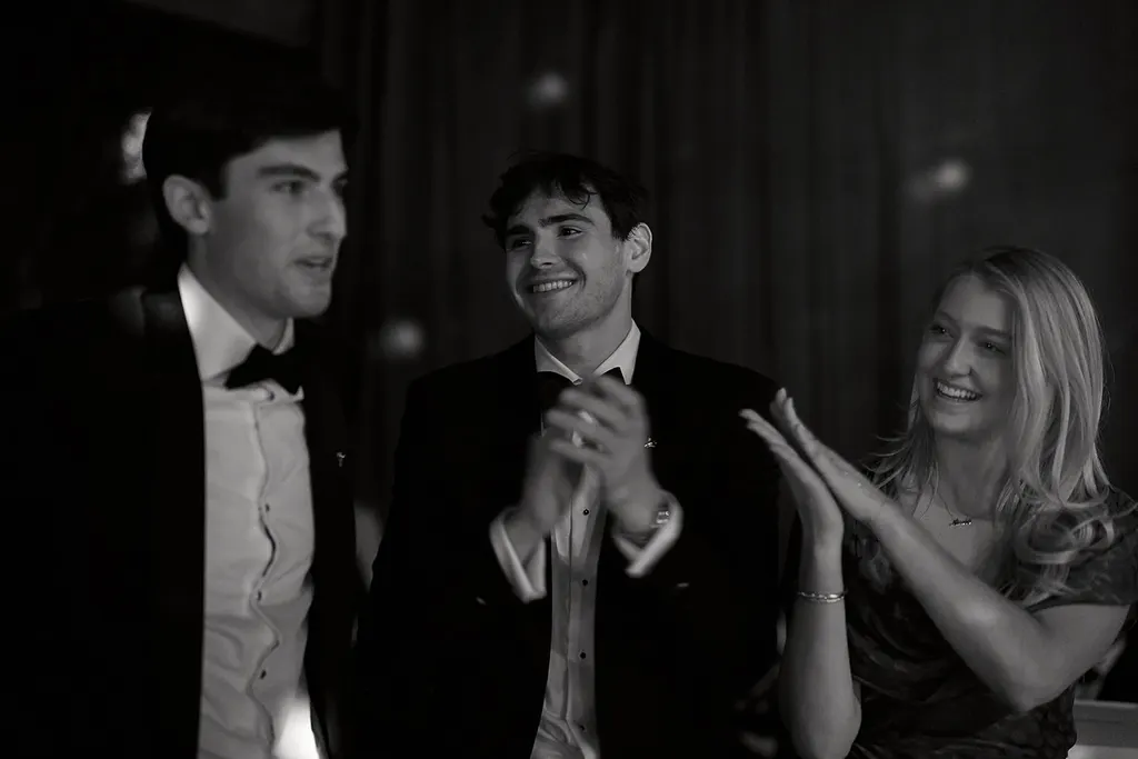 Guests applaud during the auction, in black and white.