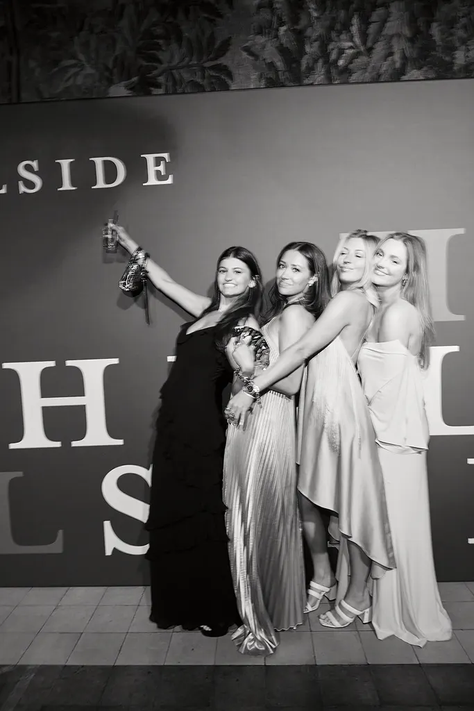 Four guests in gowns at the Hillside wall, in black and white.
