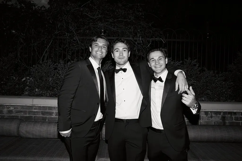 Three guests in black tie, laughing.